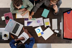 Vue aérienne d'une équipe travaillant sur des documents et graphiques autour d'un bureau, illustration de la formation des élus
