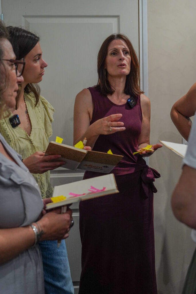 Muriel Molinier expliquant une méthode à deux participantes tenant des carnets avec des post-it, atelier de bilan de compétences